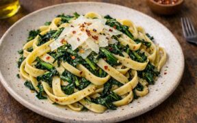 fettuccine with dandelion greens on a rustic plate
