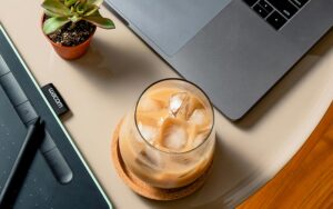 iced coffee on a table near a laptop
