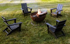wood fire pit with 4 Adirondack chairs in a yard