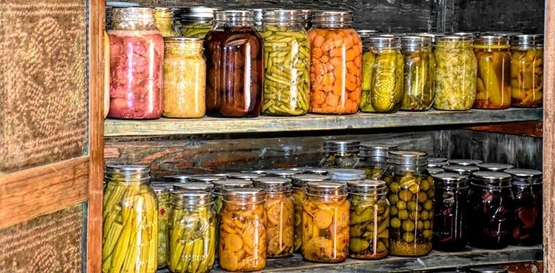 cans and jars of preserved produce on shelves